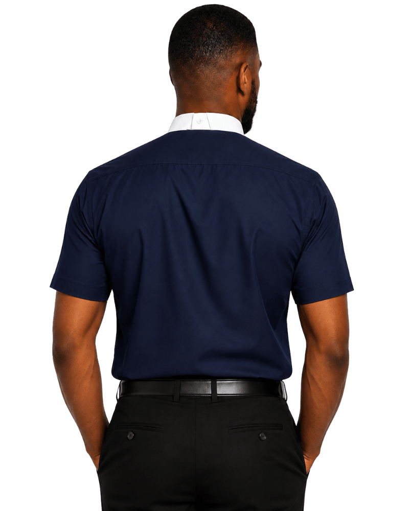 A man viewed from the back wearing a navy blue short-sleeve polo shirt, a white collared shirt underneath, a black belt, and black trousers, set against a plain white background.