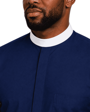 Close-up of a man wearing a navy blue clerical shirt with a contrasting white mock neck collar, shown against a plain white background.
