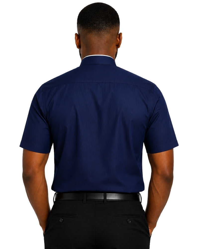 A man viewed from the back wearing a navy blue short-sleeve clerical shirt and black trousers against a plain white background.