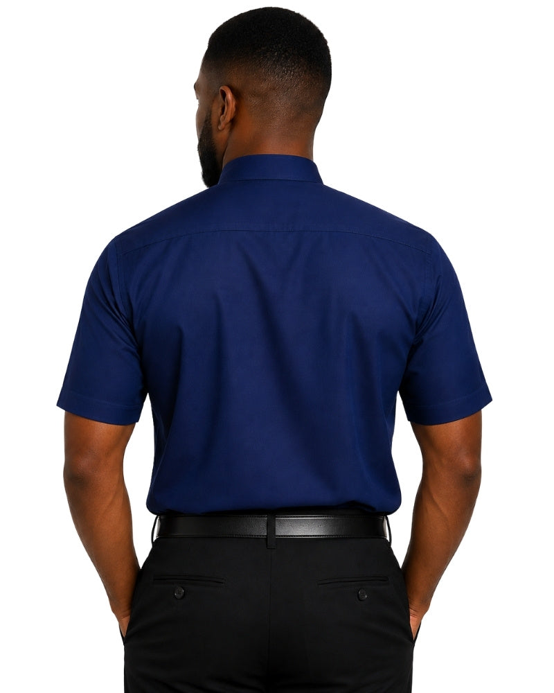 A man viewed from the back wearing a navy blue short-sleeve clerical shirt and black trousers, isolated on a white background.