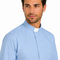 Man wearing a light blue clerical shirt on a white background