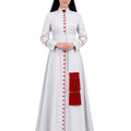 A woman modeling a Pious White Anglican Cassock With Red Trim, red decorative buttons down the front, and a large red fringed pocket on the side, photographed against a plain white background.