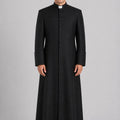 Priest wearing a black cassock on a gray background