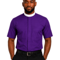 A man wearing a purple short-sleeve clerical shirt with a white collar, paired with black trousers and a black belt, standing against a solid white background.