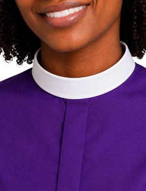 Close-up of a woman wearing a purple clerical shirt with a contrasting white collar, cropped from the mouth down.