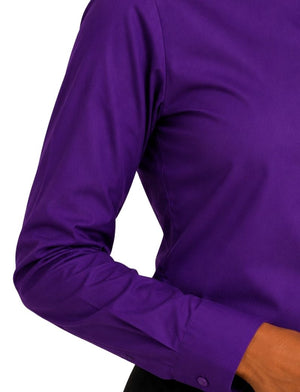 A close-up of a woman wearing a long-sleeve purple clerical shirt against a plain white background.