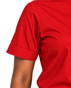 Close-up of a woman wearing a short-sleeve clerical shirt in red shown against a plain white background.