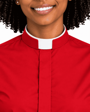 A close-up of a woman wearing a red clerical shirt with a white collar, shown from the chest up against a plain white background.
