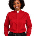 A woman wearing a red long-sleeve clerical shirt with a white collar, paired with black trousers and a black belt, shown against a plain white background.