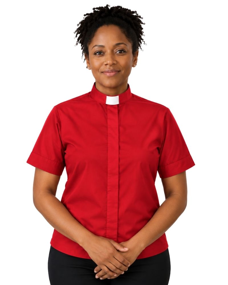 A woman wearing a short-sleeve red clerical shirt with a white collar, paired with black trousers, standing against a plain white background.