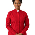 A woman wearing a red long-sleeve clerical shirt with a white collar tab, standing against a plain white background.