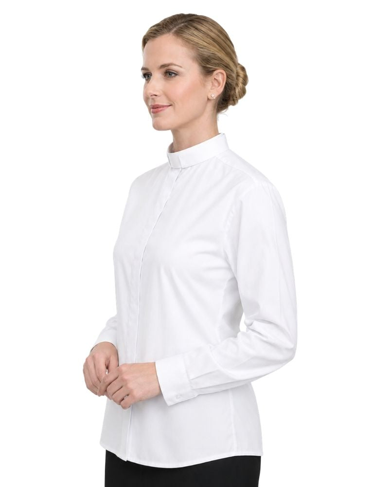 A woman wearing a white long-sleeve clerical shirt with a high mock neck, shown from a side profile against a plain white background.