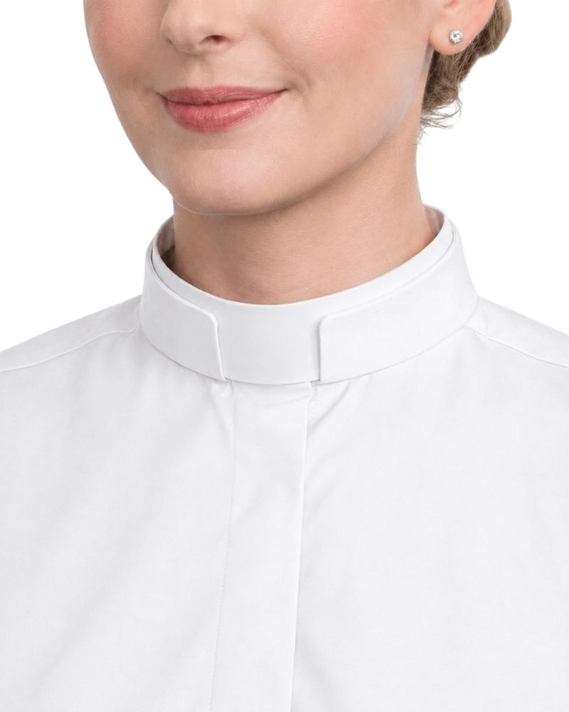 Close-up of a woman wearing a white high-neck clerical shirt or blouse against a plain white background.