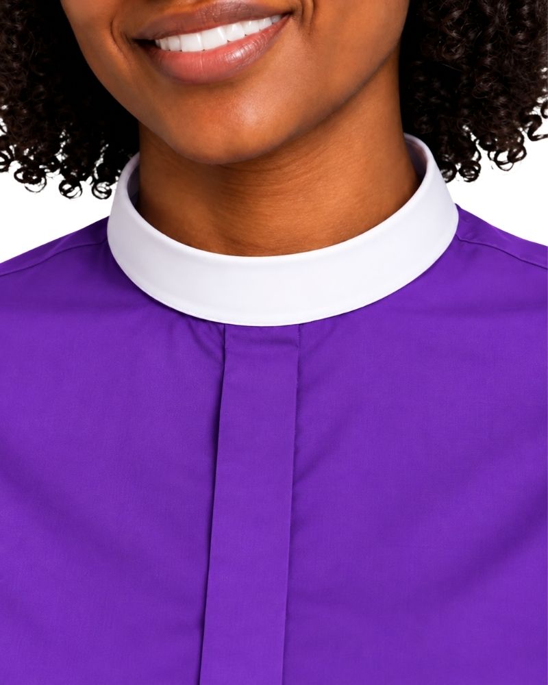 Close-up of a woman wearing a purple clerical shirt with a white collar, cropped from the mouth down against a plain white background.