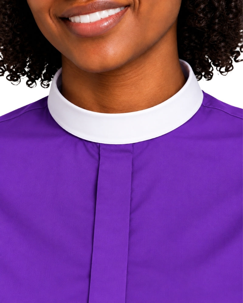 Close-up of a woman wearing a purple clerical shirt with a white collar, cropped from the mouth down against a plain white background.