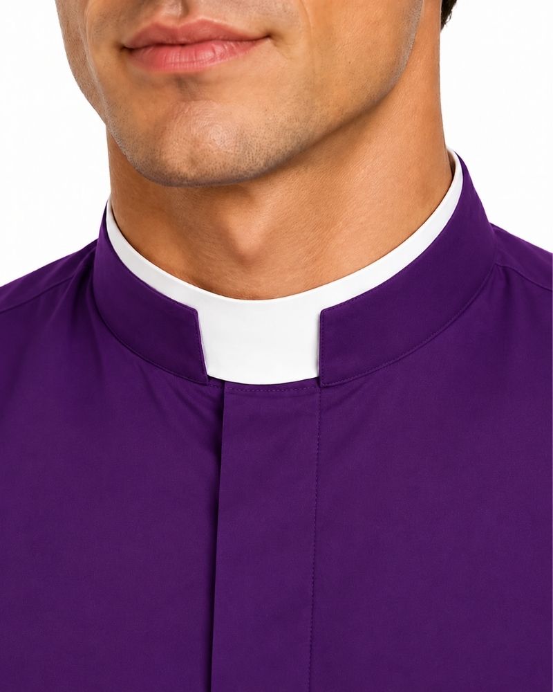 Close-up of a man wearing a purple clerical collar shirt with a white clerical collar, against a plain white background.