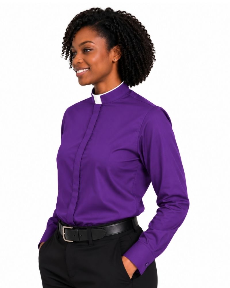 A woman wearing a purple long-sleeve clerical shirt with a white collar, paired with black trousers and a black belt, photographed against a plain white background.