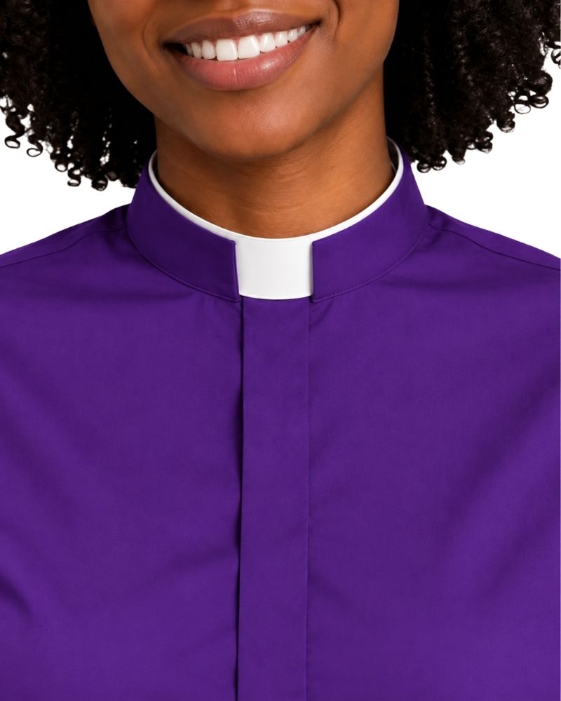 A close-up of a woman wearing a purple clerical shirt with a white collar, cropped from the mouth down against a plain white background.