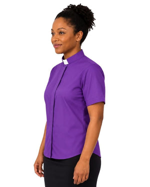 A woman wearing a purple short-sleeve clerical shirt with a white collar tab, shown in profile against a plain white background.
