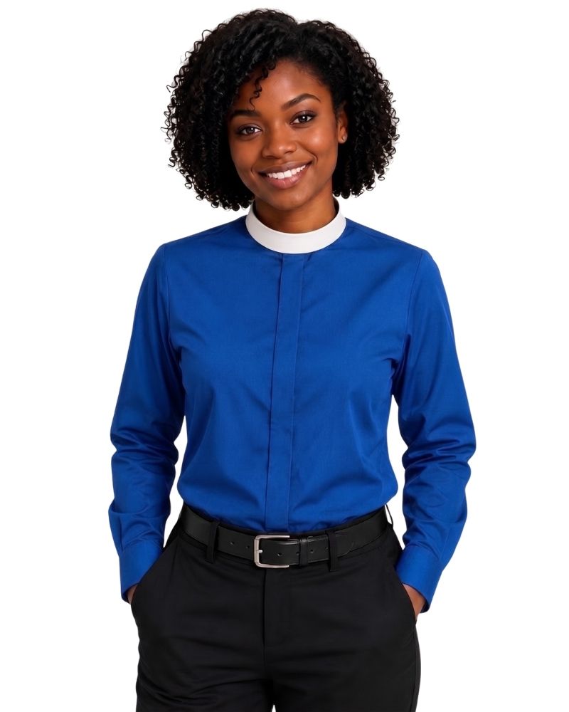 A woman with curly black hair wearing a royal blue long-sleeve clerical shirt with a white mock neck collar, paired with black trousers and a black belt, against a plain white background.