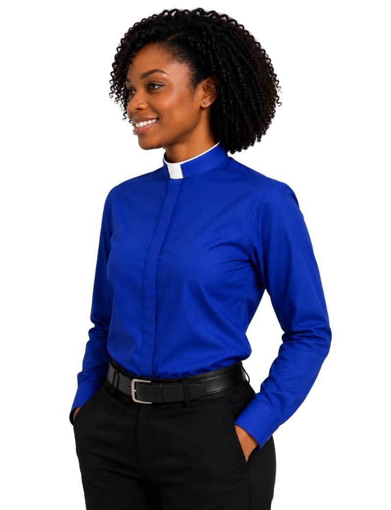 A woman wearing a royal blue long-sleeve clerical shirt with a white collar, paired with black trousers and a black belt, shown against a plain white background.