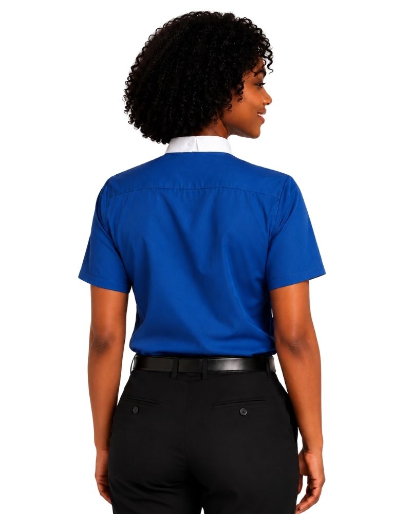 A woman shown from the back wearing a royal blue short-sleeve clerical shirt with a white collar, paired with black trousers and a black belt, against a plain white background.