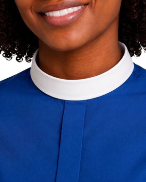 Close-up of a women wearing a royal blue clerical shirt with a contrasting white high collar, showing the neck, lower face, and collar detail against a white background.
