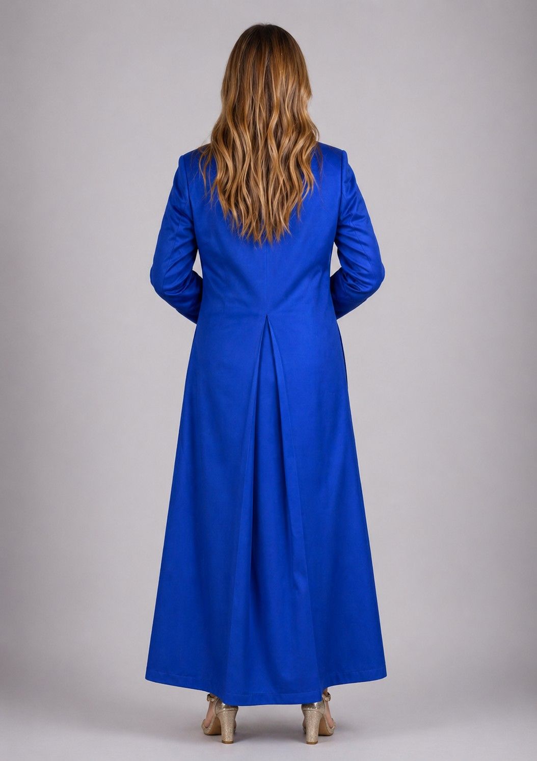 Woman wearing a blue dress with a plain background
