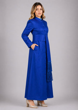 Woman wearing a blue dress with a belt and fringe details on a gray background