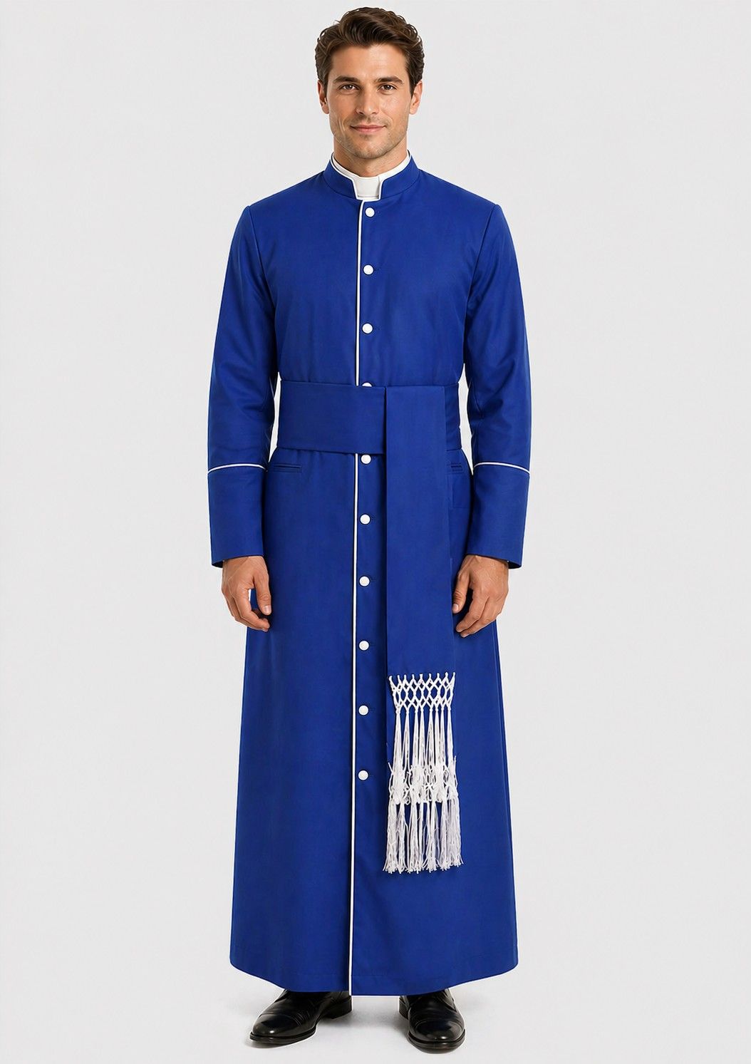 Man wearing a blue robe with white buttons and tassels on a plain background