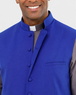 Man wearing a blue vest over a gray shirt with a white collar.