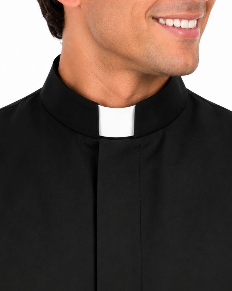 A close-up of a man wearing a Sanctus Black Roman Robe with a white clerical collar, shown from the chest up against a plain white background.