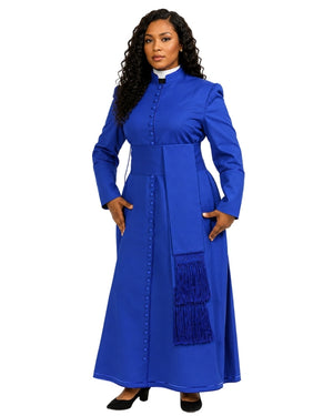 A woman modeling a long-sleeved royal blue cassock with a high mock neck, front button placket, side pockets, and a matching blue fringe detail on the skirt, shown against a plain white background.