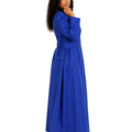 A woman modeling a long royal blue cassock with long sleeves, a defined waist, and a flowing skirt, shown against a plain white background.