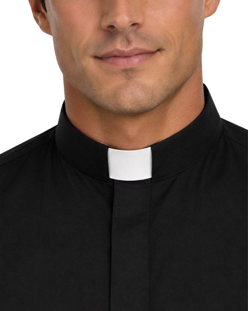 A close-up of a man wearing a black clerical shirt with a white collar tab, shown against a plain white background.