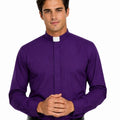 A man wearing a purple long-sleeve clerical shirt with a white collar tab, paired with a black belt and black trousers, standing against a plain white background.