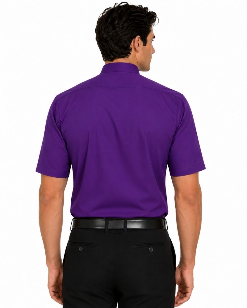 A man viewed from the back wearing a solid purple short-sleeve clerical shirt and black trousers, against a plain white background.