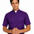 A man wearing a purple short-sleeve clerical shirt with a white collar tab, paired with a black belt and black pants, against a plain white background.