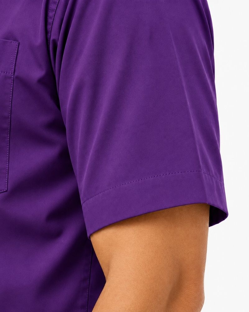 Close-up of a person wearing a solid purple short-sleeve clerical shirt, showing the sleeve, cuff, and part of the arm against a plain light background.