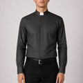Man wearing a black clerical shirt with a white collar on a gray background