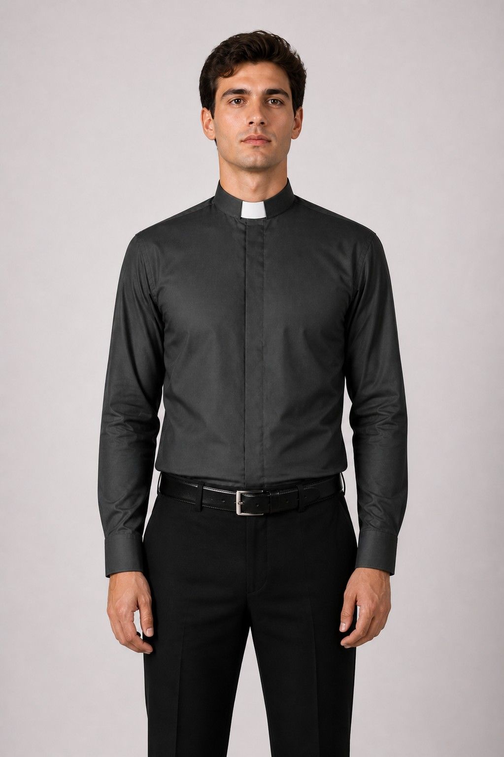 Man wearing a black clerical shirt with a white collar on a gray background