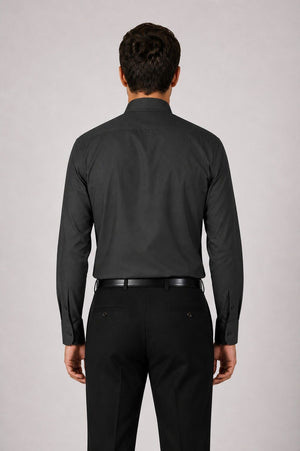 Man wearing a black dress shirt and pants on a light gray background