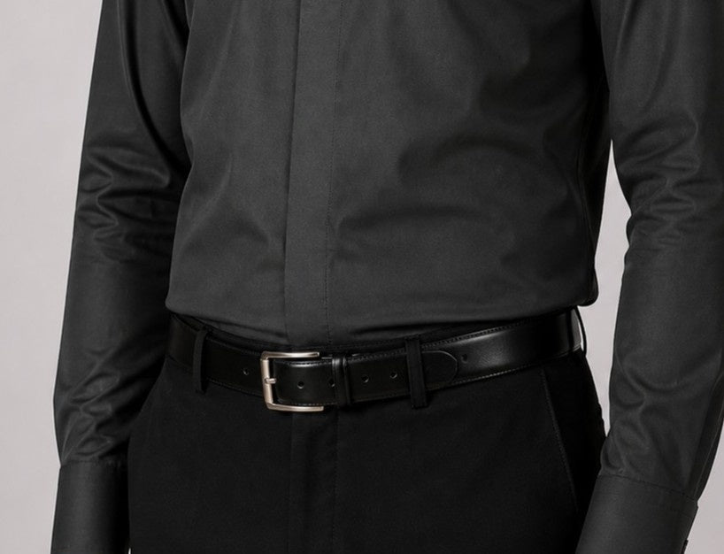 Person wearing a black shirt and pants with a black belt on a light gray background