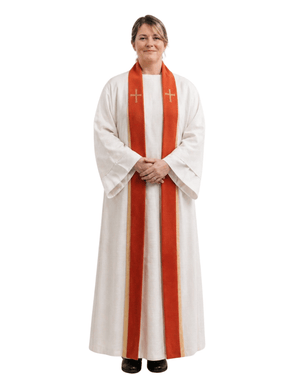 A woman modeling a white liturgical robe with a prominent orange-red striped stole featuring two gold crosses, set against a plain white background.