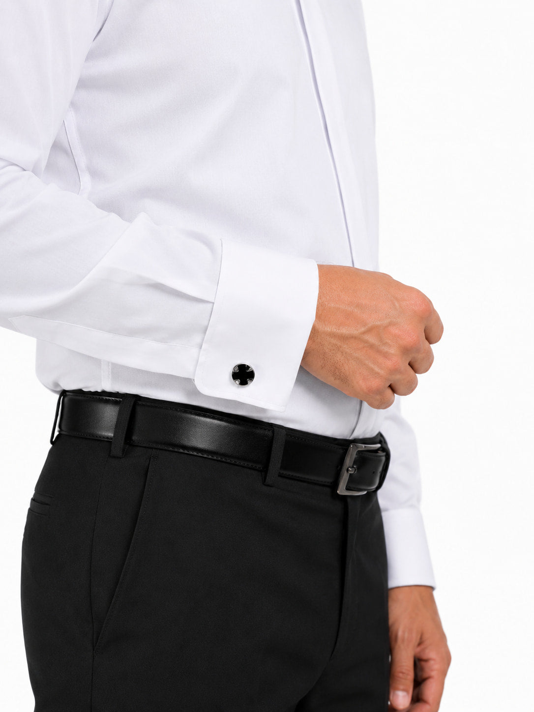Man wearing a white clerical shirt with black cufflinks and black pants on a white background
