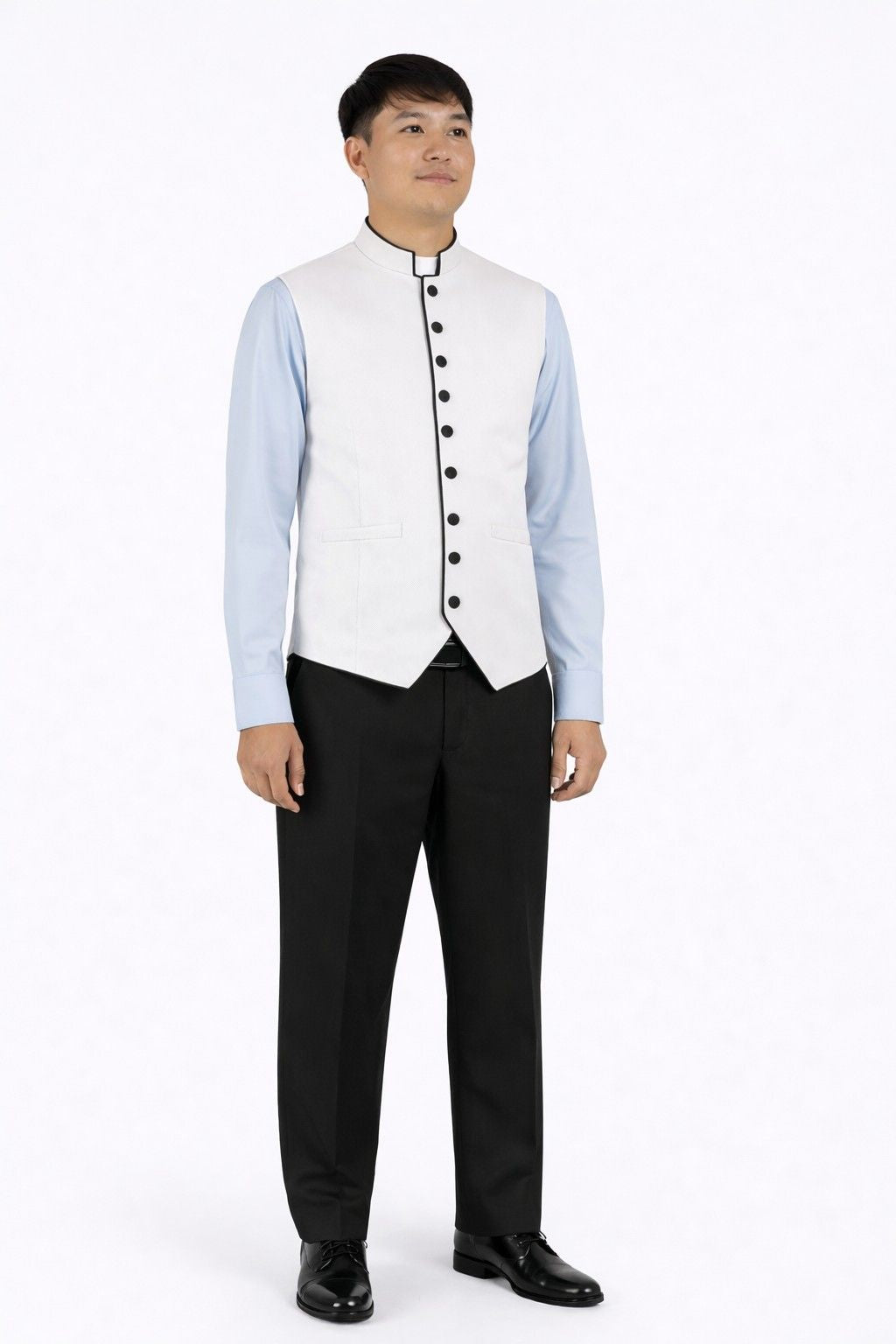 Man wearing a light blue dress shirt, white vest with black buttons  and black pants on a white background