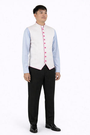 Man wearing a light blue dress shirt, white vest with light purple buttons, black pants, and black shoes on a white background