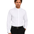 Man wearing a white clerical shirt and black pants on a white background