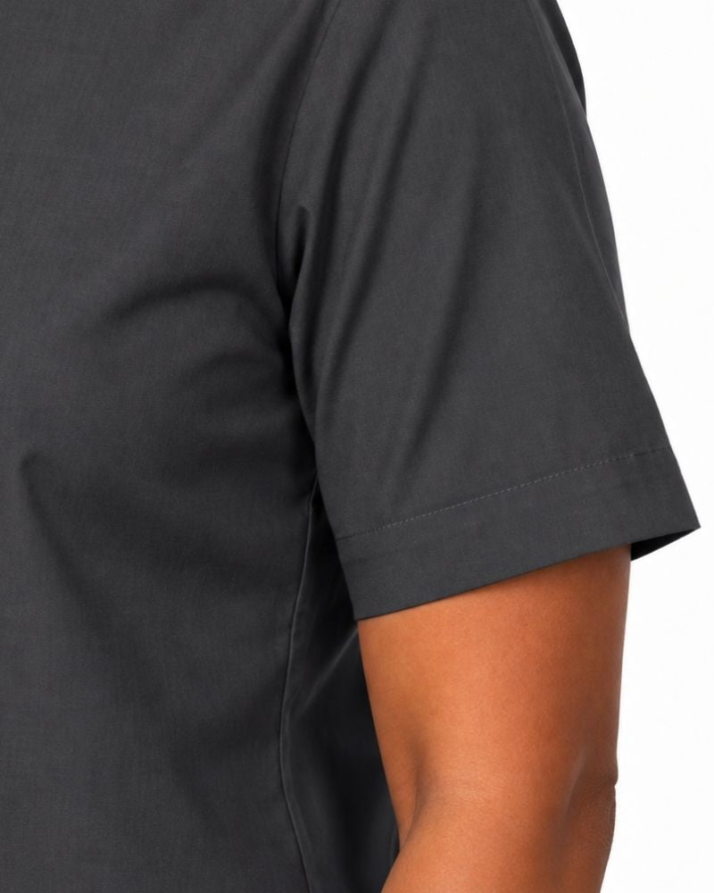 Close-up of a woman wearing a dark charcoal gray short-sleeve clerical shirt, showing the sleeve cuff and side seam against a plain white background.