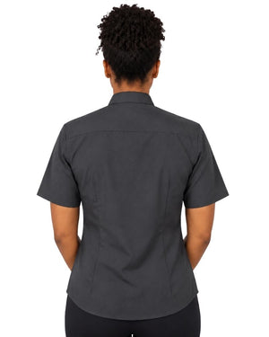 A woman viewed from the back wearing a dark charcoal gray short-sleeve clerical shirt and black pants, set against a plain white background.